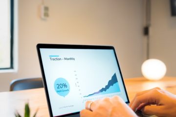 person using macbook pro on brown wooden table