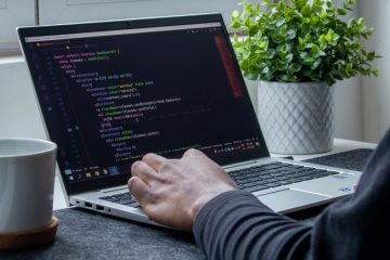 person using macbook pro on table