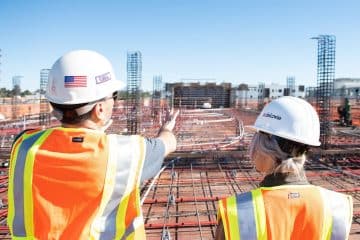 man in white hard hat standing on brown wooden dock during daytime